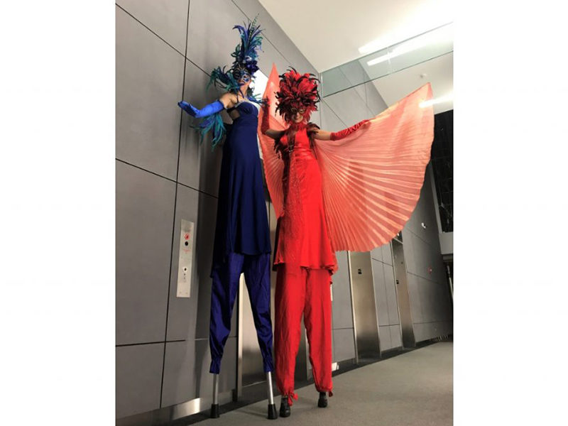 Two Stilt Walkers posing for photo.