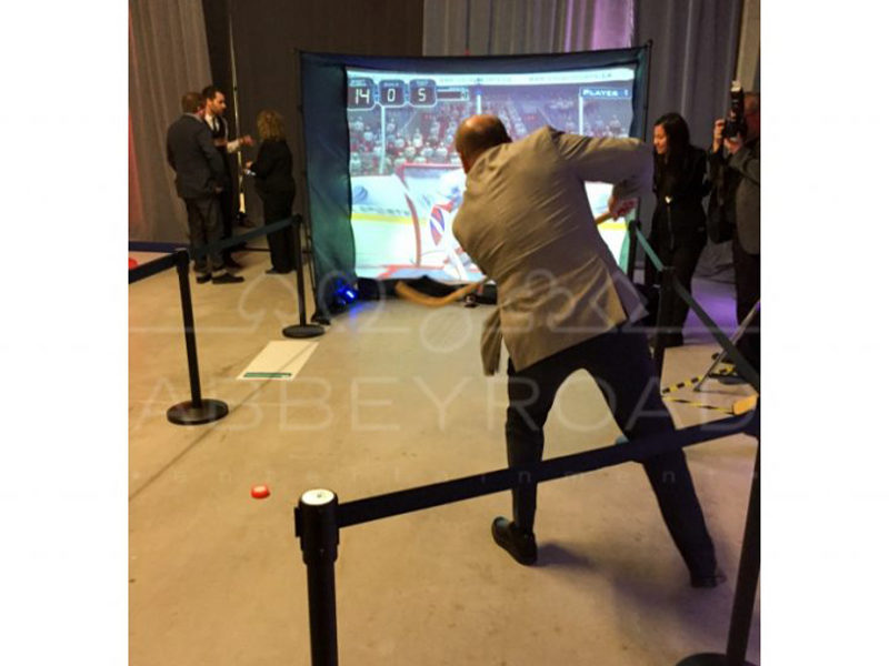 Man shoots hockey puck into goal.