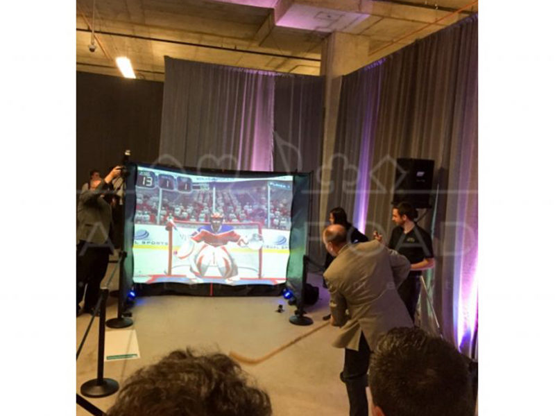 Man playing hockey on the Portable Golf Simulator.