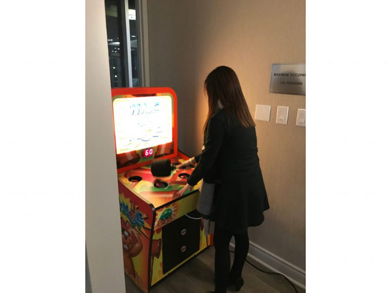 Woman playing the Whac-A-Mole Arcade.