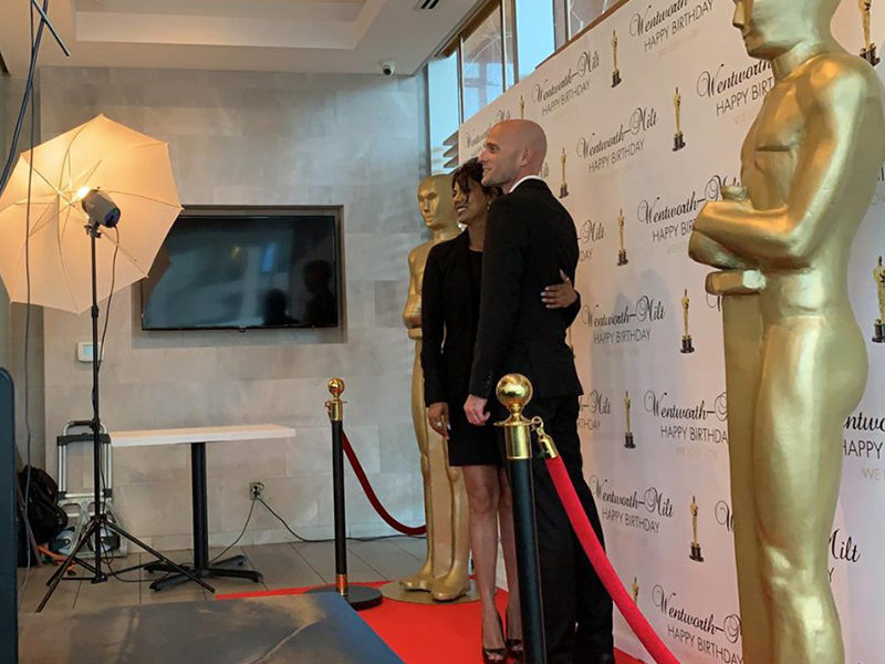 People posing for photo next to two Giant Award Statue Rentals.