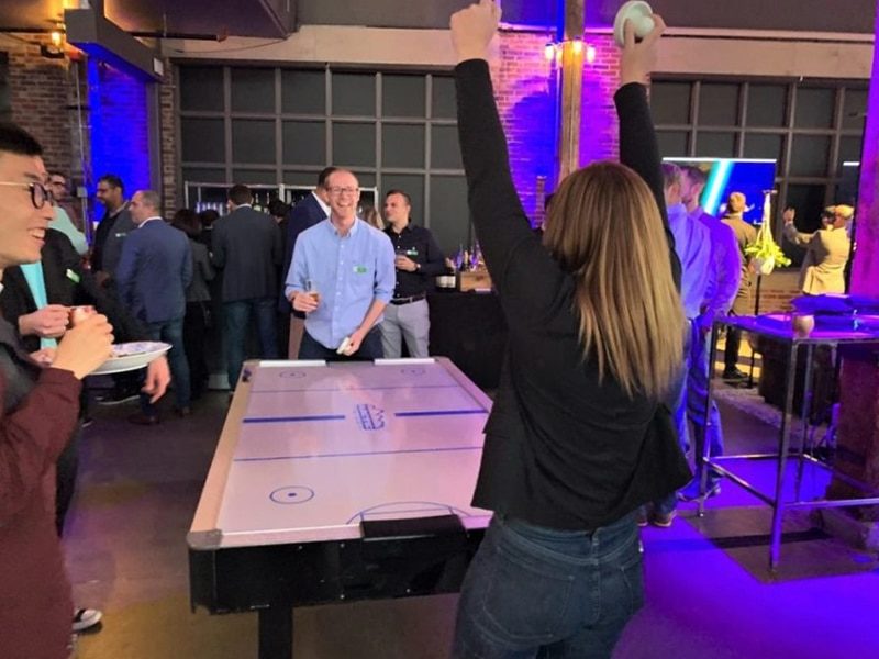 Woman Cheering after scoring in her Air Hockey game.