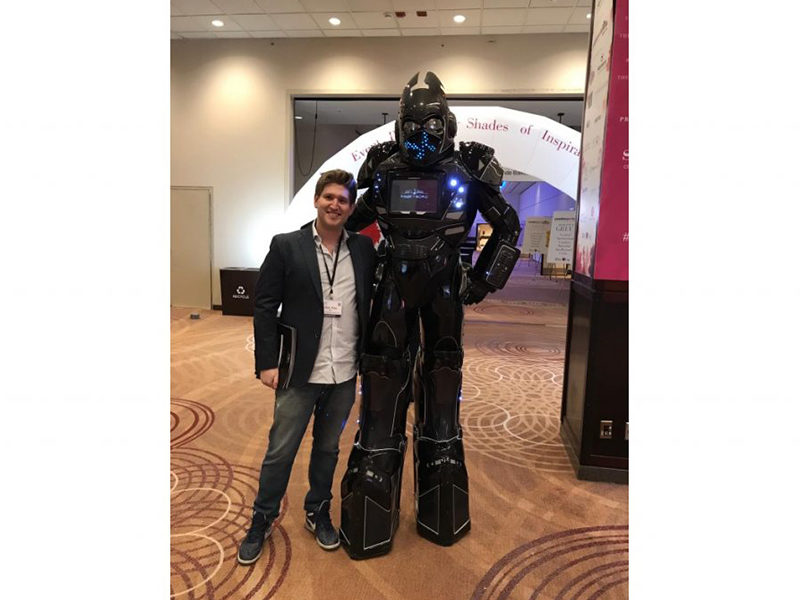 Giant LED Robot rental standing with man at event.
