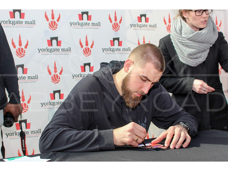 Man signing sports card at event.