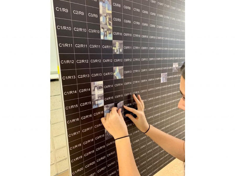 Person placing tiles onto their Photo Mosaic Wall.