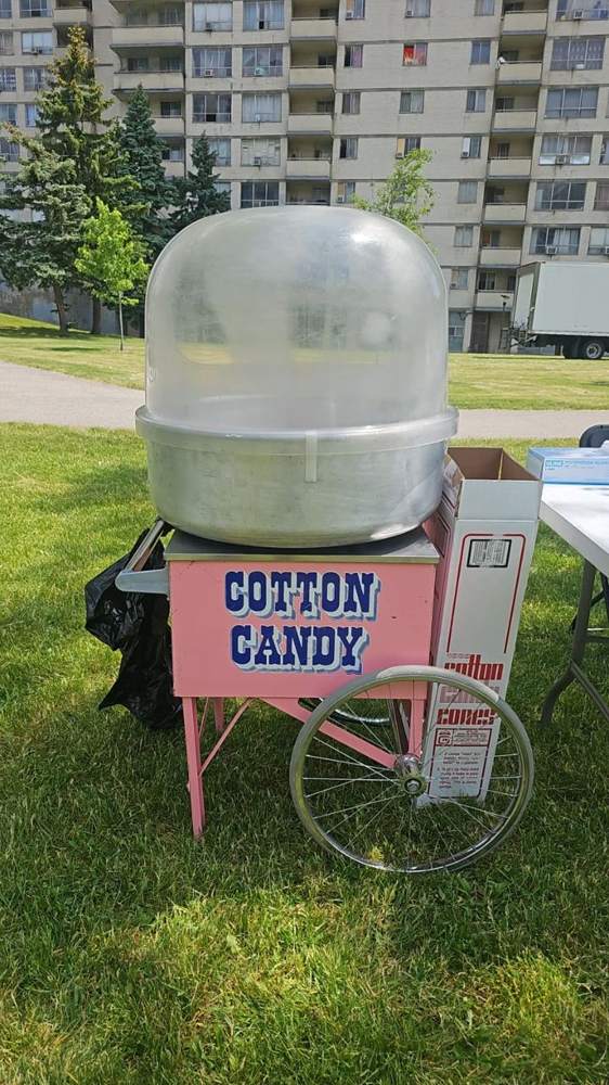 Vintage cotton candy cart set up on grass at an outdoor fun fair