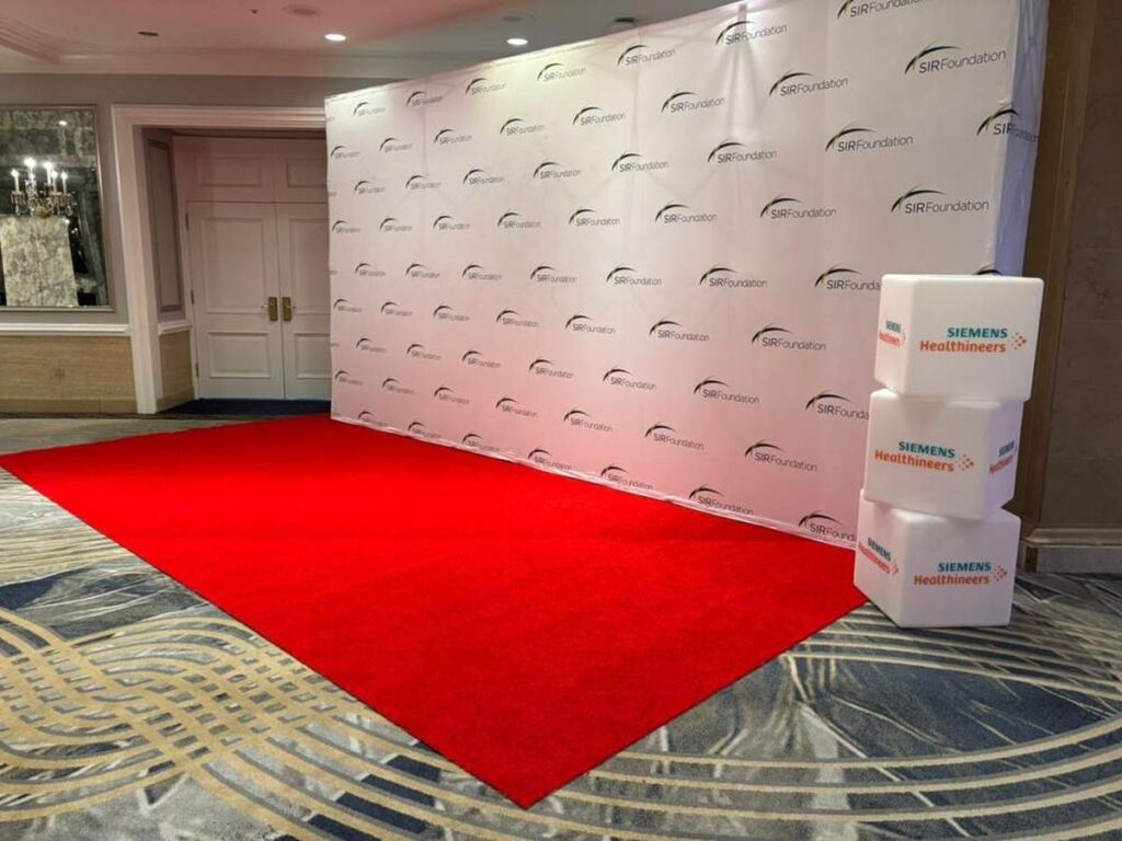 Red carpet step and repeat backdrop with a company logo
